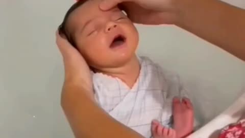 A BABY ENJOYING A REFLECTION MASSAGE FROM THEIR MOTHER