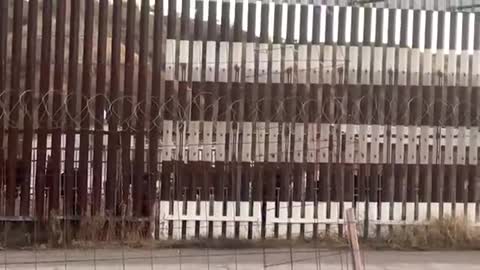 NOGALES, ARIZONA: A PAIR OF UNDOCUMENTED INDIVIDUALS ARE LOOKING FOR A SPOT TO SCALE THE WALL