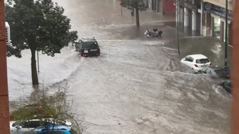 Car Drives Through Flooded Street in Spain