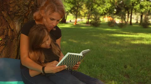 Blondie mama and her cute baby girl reading a book