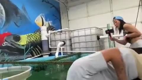 Guy Pretends to Get Knockout in Fish Tank While Feeding Fish With His Mouth