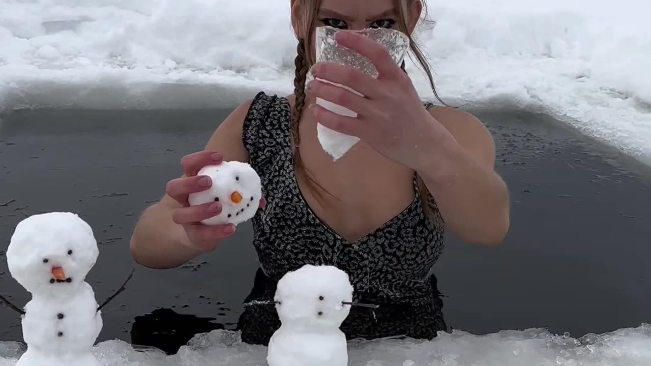 girl playing with ice in cold water