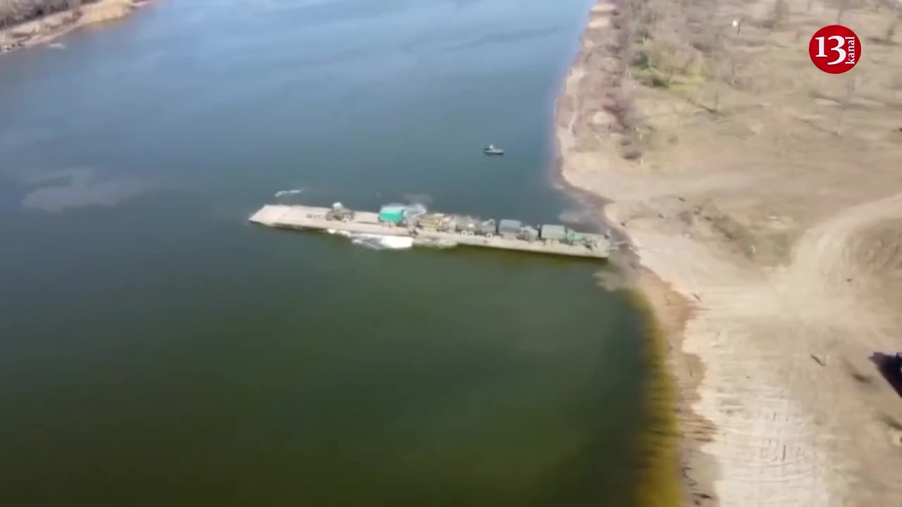 Ukrainian army preparing for battle by transporting heavy artillery across river via pontoon bridge