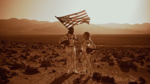 A man and woman talking while standing on a rockey terrain