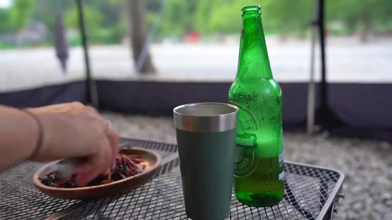 Outdoor camping, tent under the tree when the weather is too hot to enjoy cool food