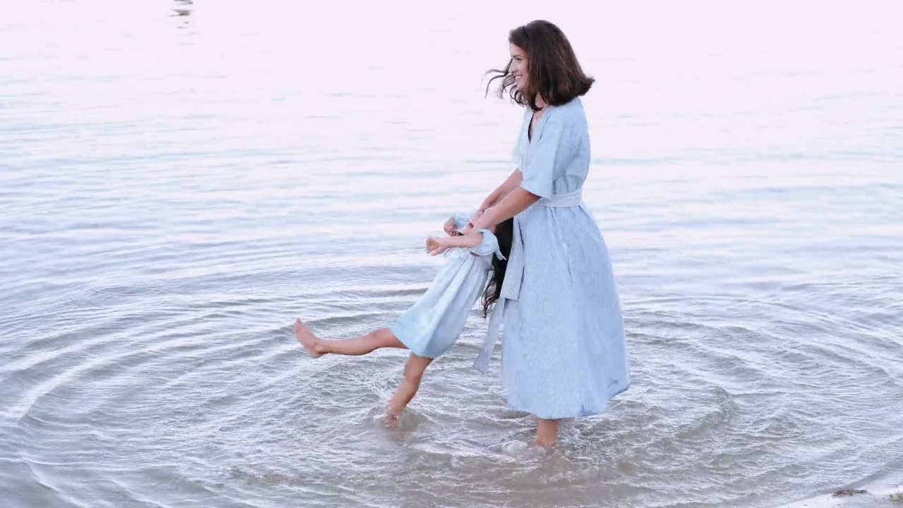 Mother play with her daughter in water