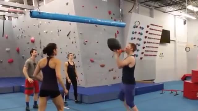 Girl Attempts to Catch Sandbag and Falls Over