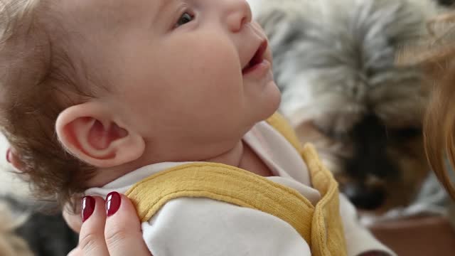 A cute baby playing with his mother