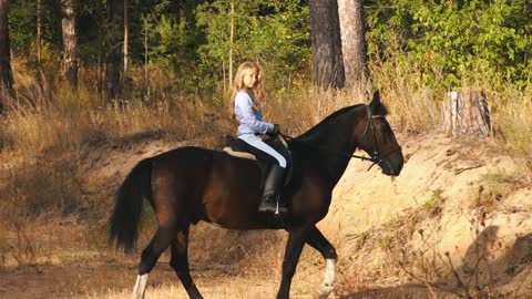 girl on a horse galloping through the forest