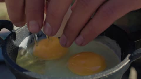 Preparing eggs at a campsite