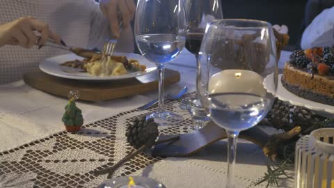 Elegant table with people eating at christmas dinner