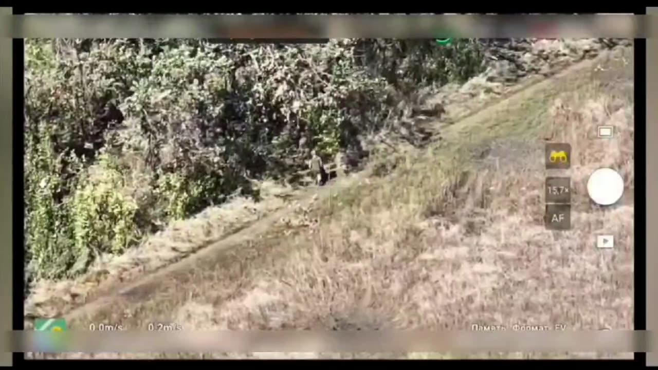 A Russian soldier drags a wounded captured enemy soldier from the battlefield. Helps him.