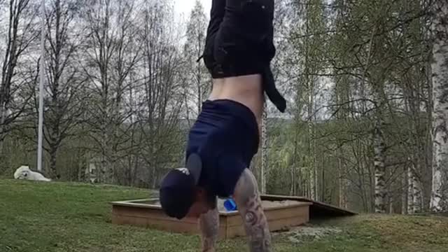 Guy Performs Handstand Push Ups While Balancing Himself Over Two Axes