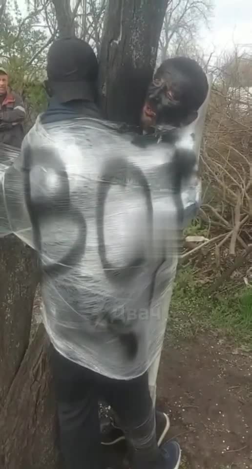 Ukraine: Civilians have faces painted black, tied to tree
