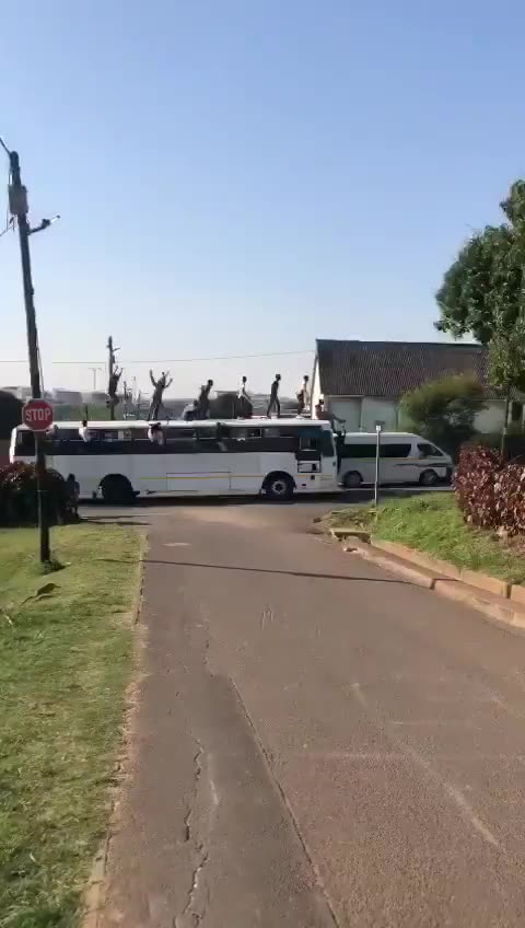 Group of youths ride on top of a moving bus in Durban