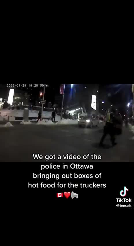 Police in Ottawa bringing out boxes of hot food for the truckers