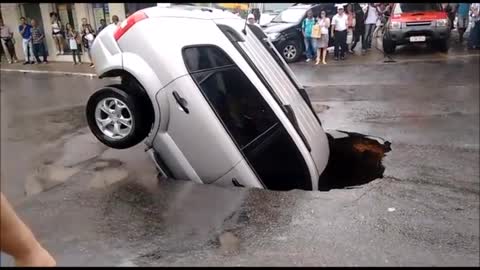 Car Sinks Into Major Pothole