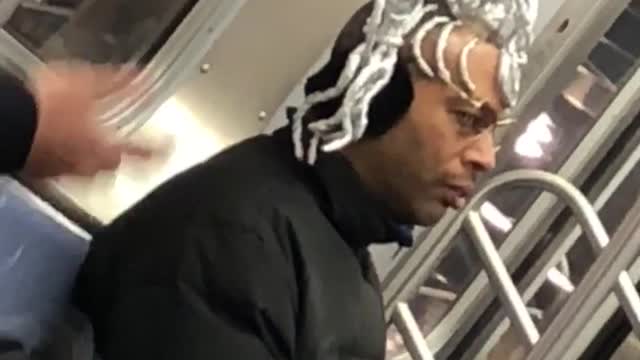 Man on subway with silver tinfoil hair