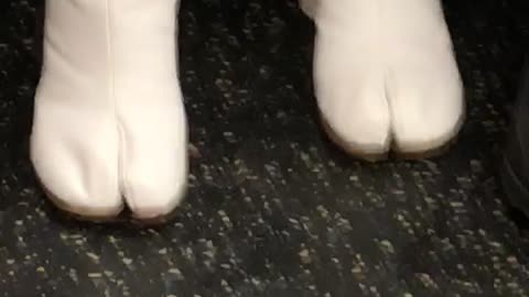 Woman wears horse toe boot on subway