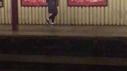 Hoodie woman does odd dance while waiting for subway