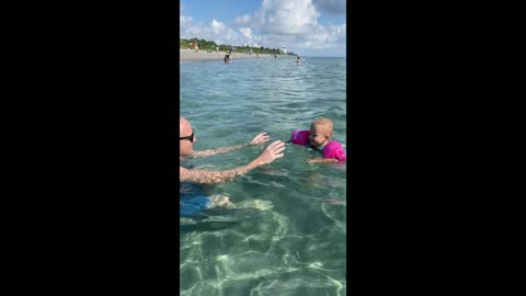 Toddler first time swimming at the sea