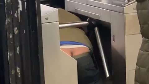 Man crawling under subway butt crack showing