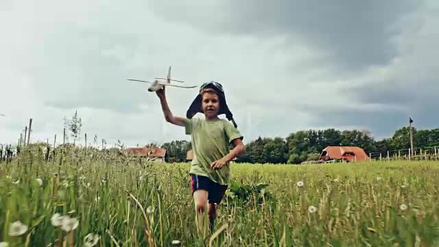 SLO MO petit garçon avion survolant de l’herbe