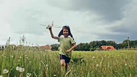 SLO MO petit garçon avion survolant de l’herbe