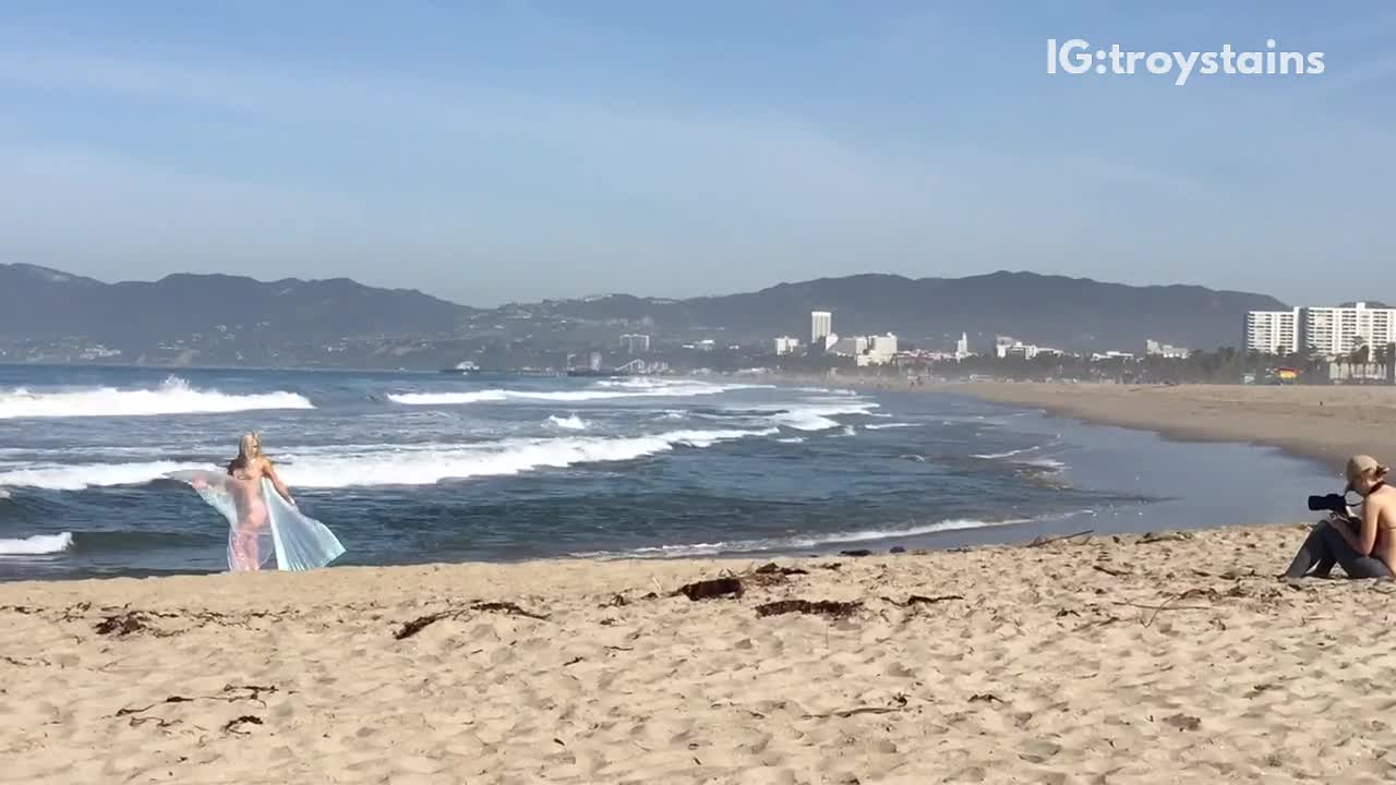 Woman in glittery blue outfit photo shoot on beach