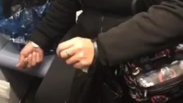 Lady crushing nuts in hand on subway