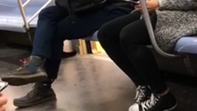 Hoodie guy looking at phone picks own booger and eats it on subway