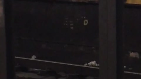 Man lays at the edge of subway station platform