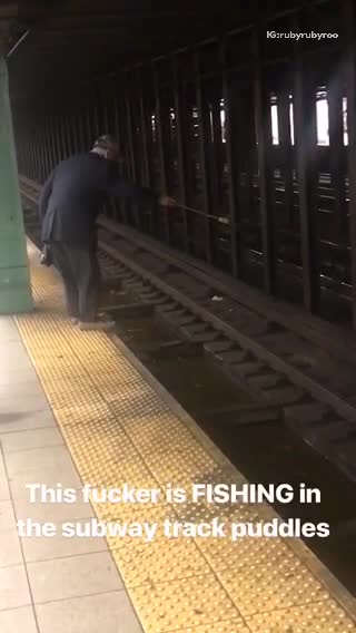 Old guy blue suit fishing subway train tracks