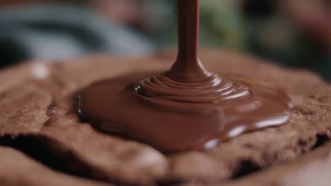 chocolate fondue is poured over a cake