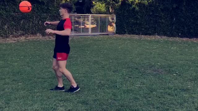 Kid in red and black kicks ball lands on back neck