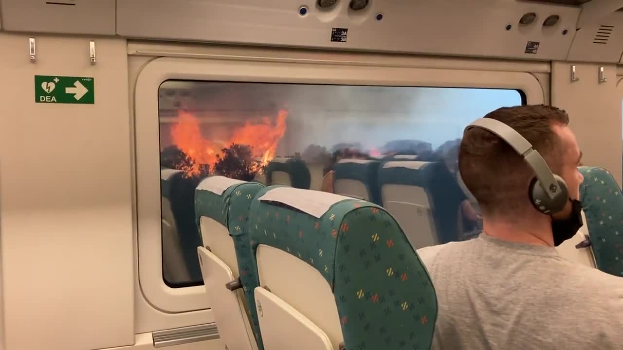 Trem cercado por incĂȘndios florestais durante onda de calor no oeste da Espanha.