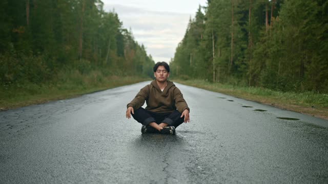 Man Doing Yoga In The Middle Of The Road