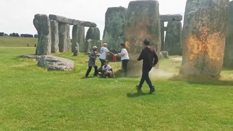 What appear to be @JustStop_Oil supporters are spraying orange paint on the stones of Stonehenge.