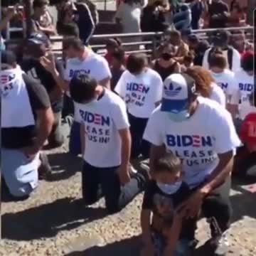 Immigrants Kneel At The Border With 'Biden Please Let Us In' T-Shirts