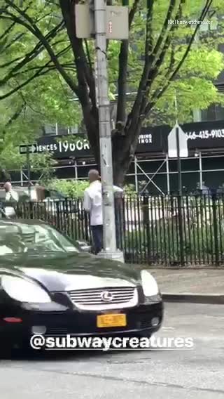 Man in white spinning a broom on street