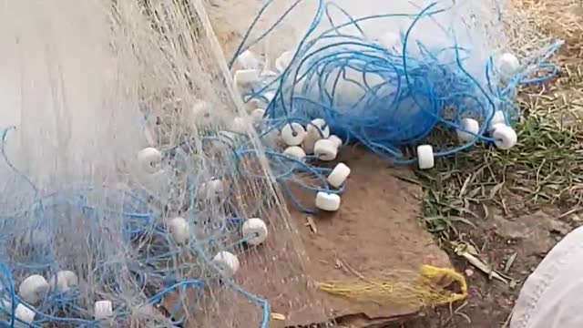 A fisherman weaving his fishing net