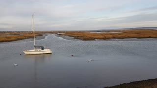 Boat on a river . In Lymington. Near a castle .