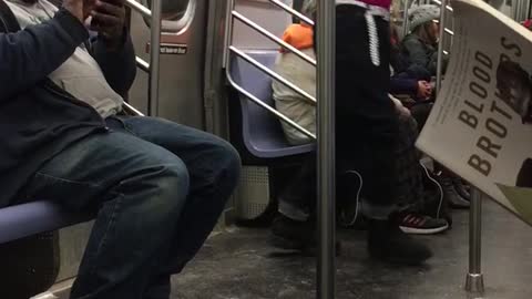 Pink shirt guy practices boxing in subway car