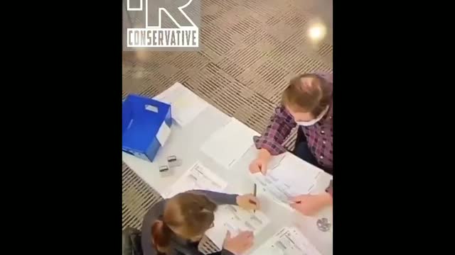 Poll worker filling out Biden Ballots