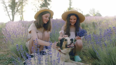 two princesses playing in the flower garden with their beloved dog