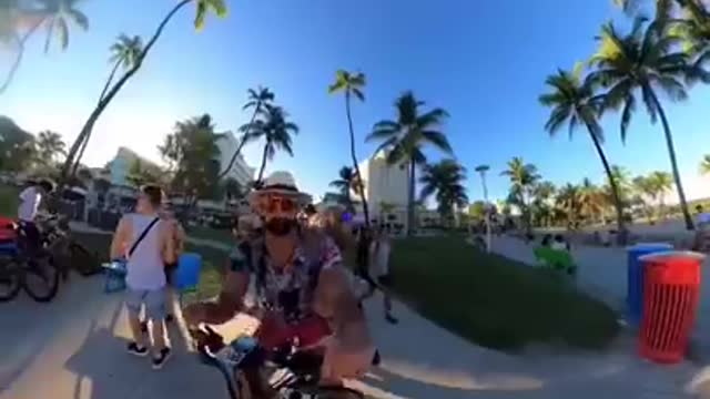 Backpack dog spreading good vibes on the beach! #ebike #dogbackpack #goldendoodle #miami