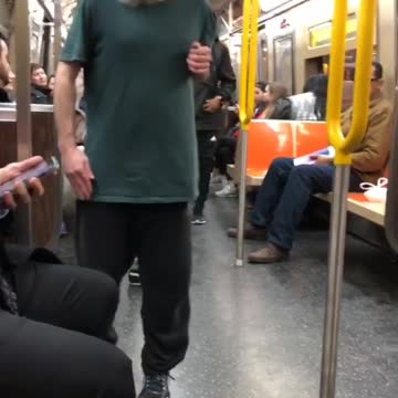 Drunk guy spins around fast inside a subway train