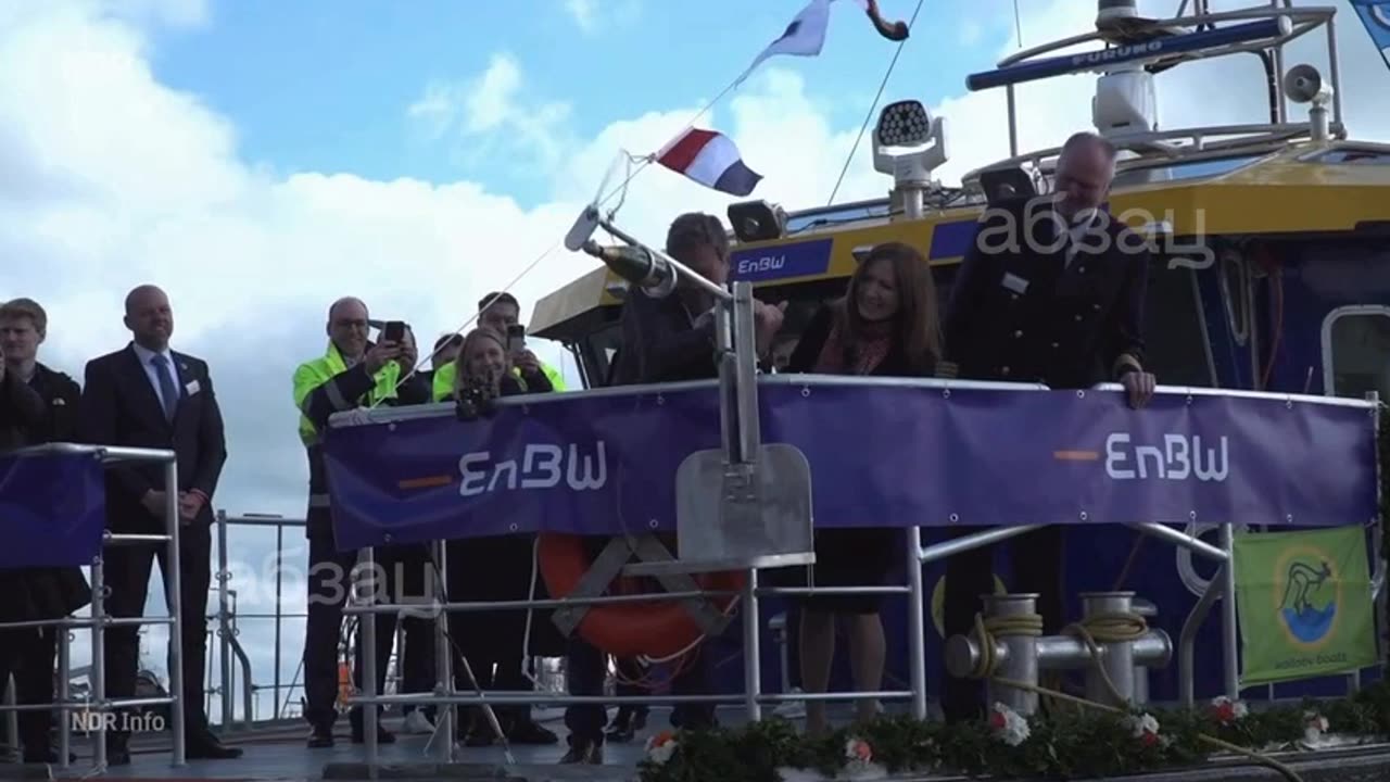 Robert Habeck versucht, eine Champagnerflasche zu zerschlagen.