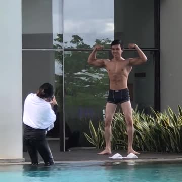 Guy in black swim shorts posing for picture