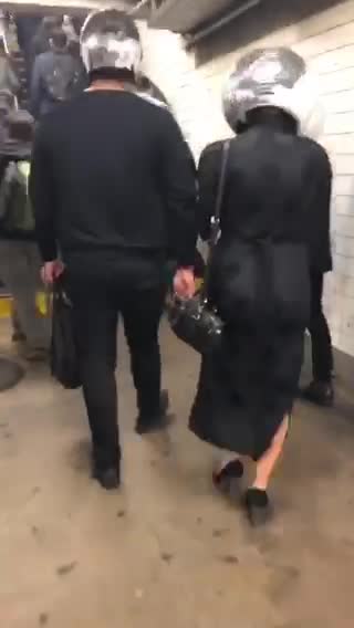 People wearing disco balls as hats in subway station